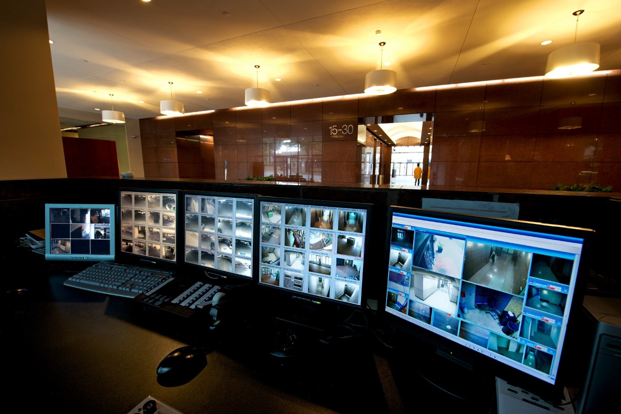 Bank of security monitors at the security desk in the lobby of a high-rise office building.