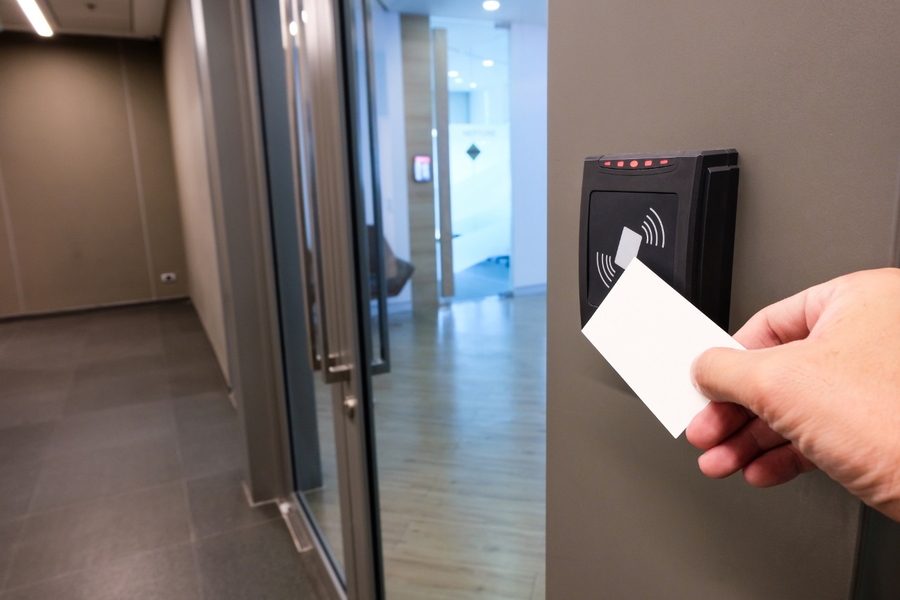 Men hand reaching to use RFID key card to access to office building area and workspace. In building security only for authorized person